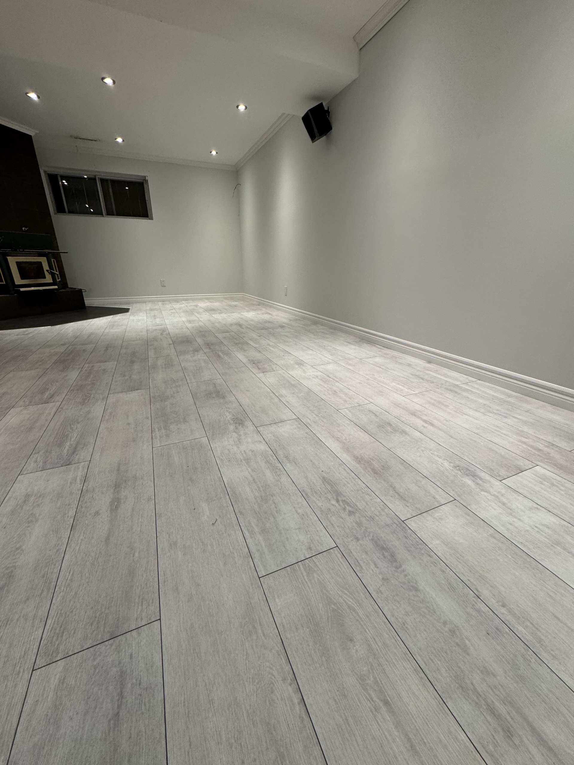 Contemporary grey laminate flooring installation in a finished basement