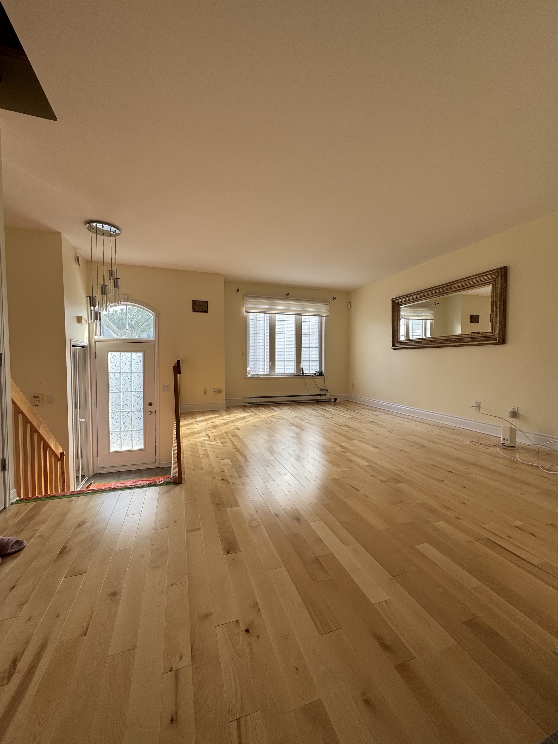 Spacious open concept living area featuring newly installed birch hardwood flooring