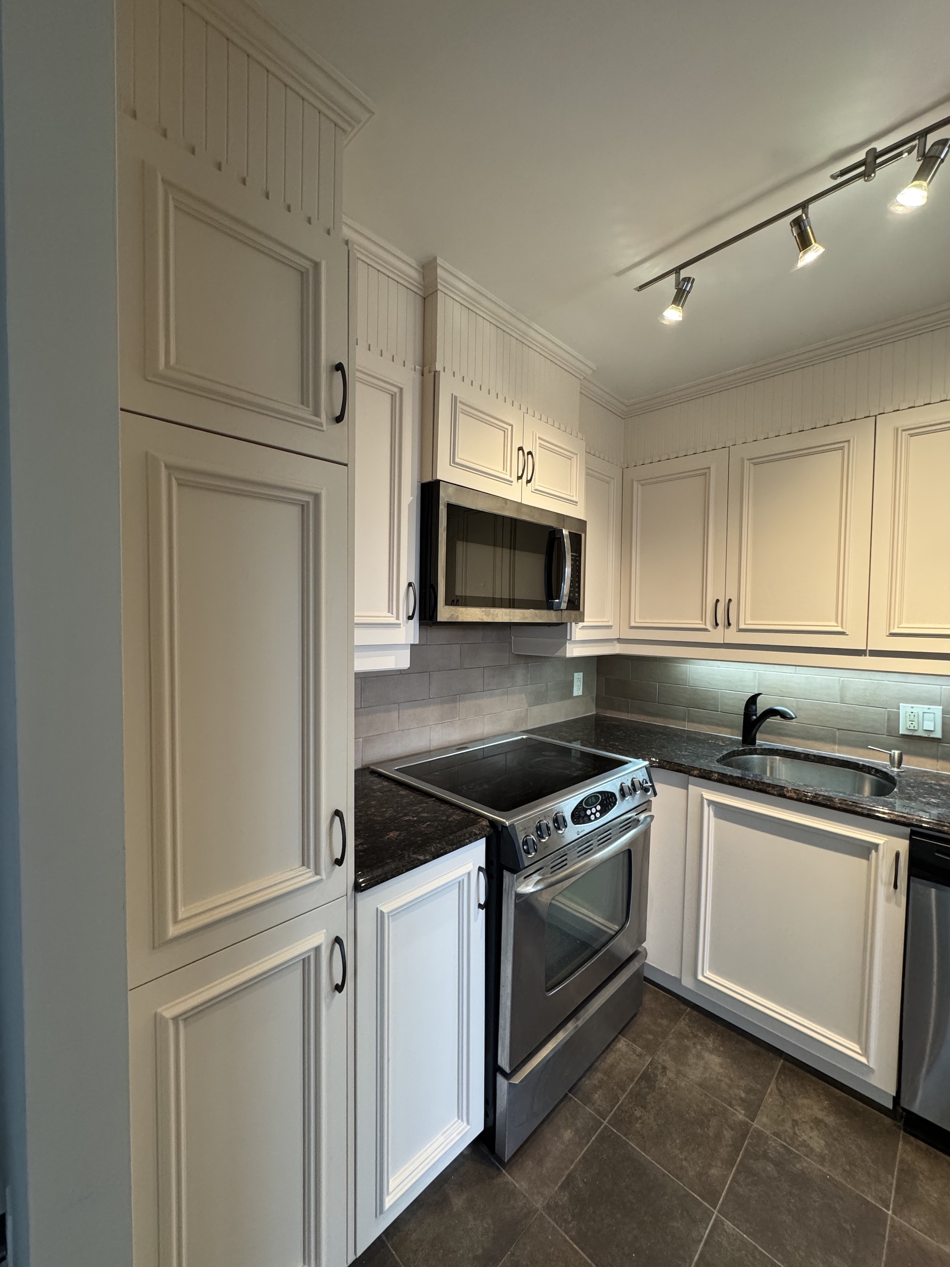 Classic cream kitchen cabinetry with beadboard detail and crown molding