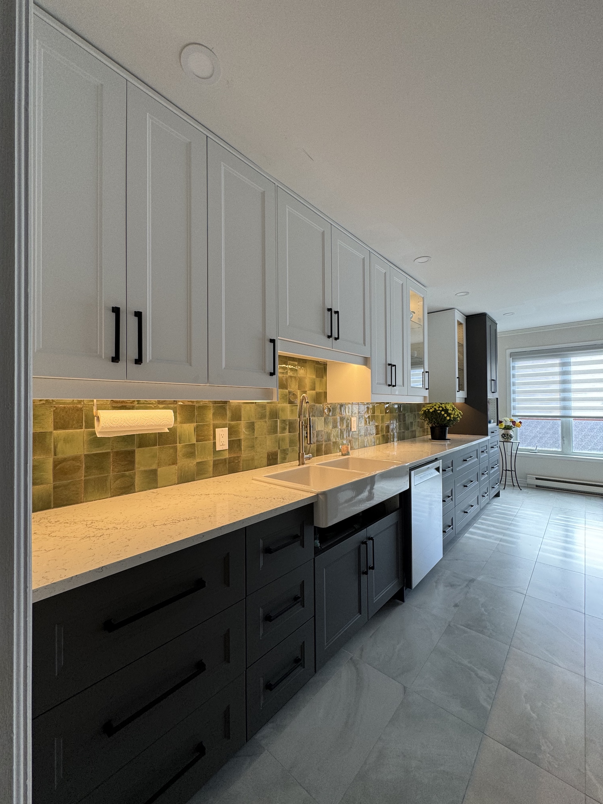 High-end kitchen renovation in Montreal with white shaker cabinets and charcoal island