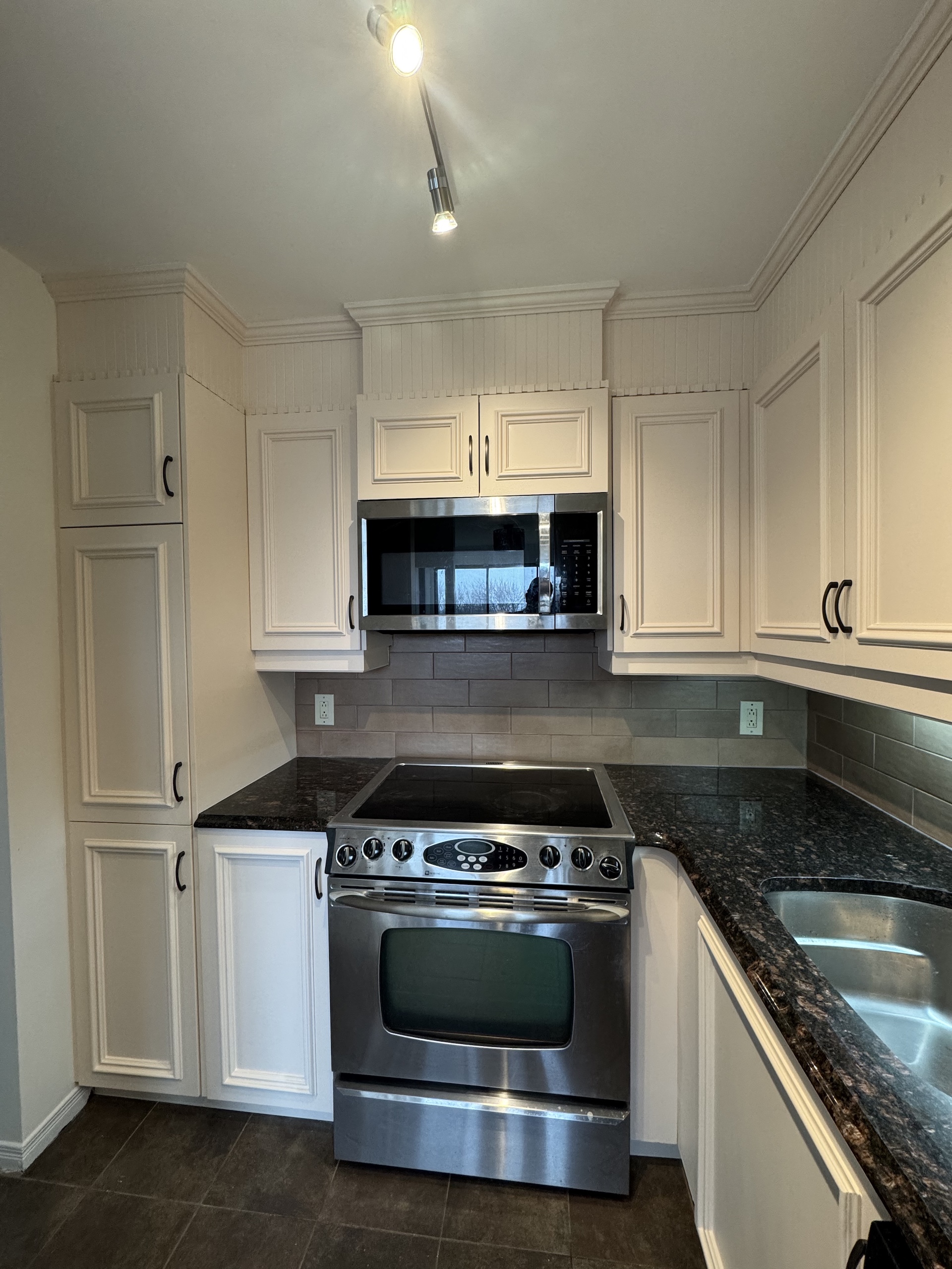 Front view of high-end transitional kitchen featuring stainless steel range