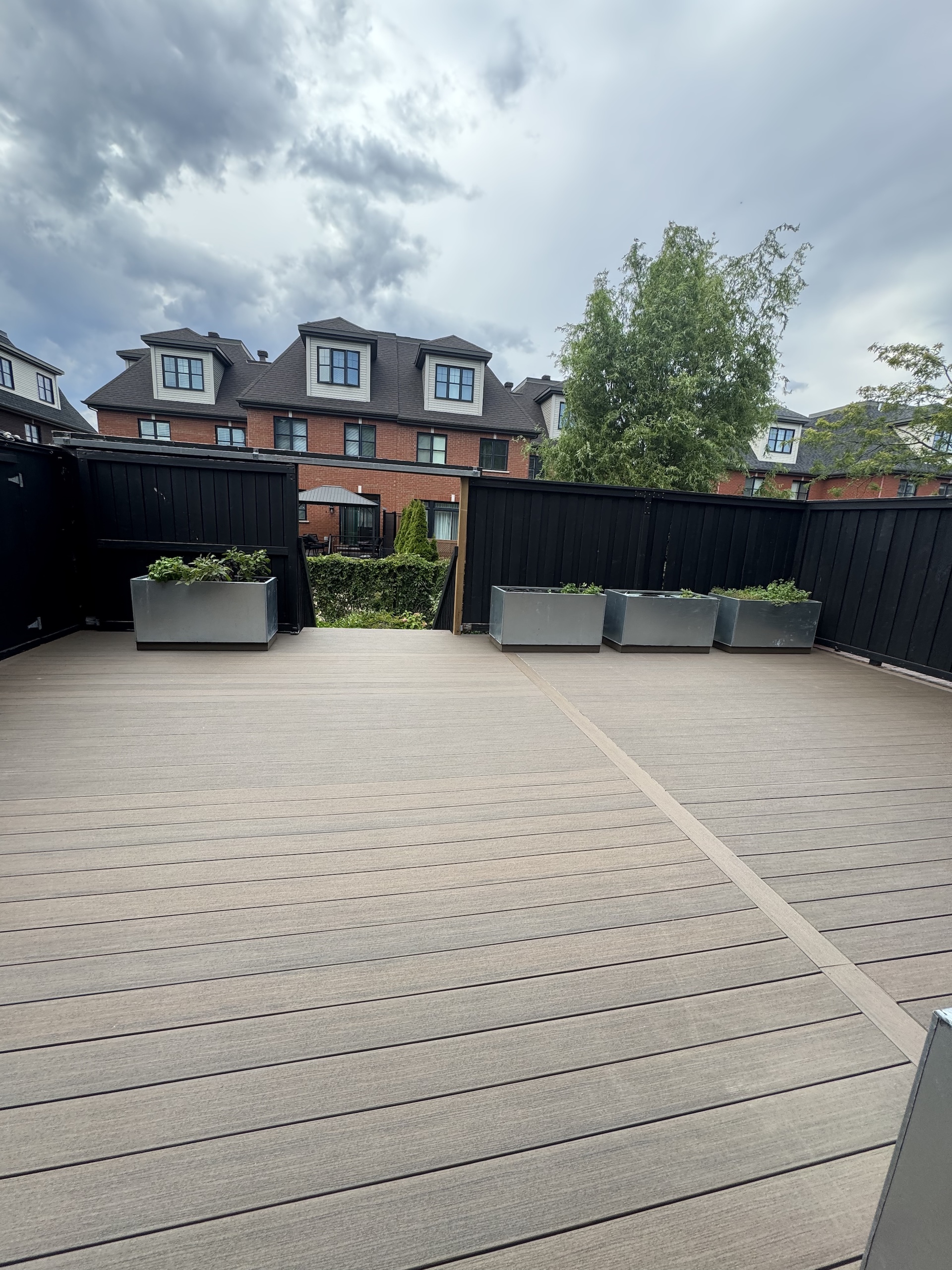 Wide view of a completed composite deck project featuring seamless layout and landscaping