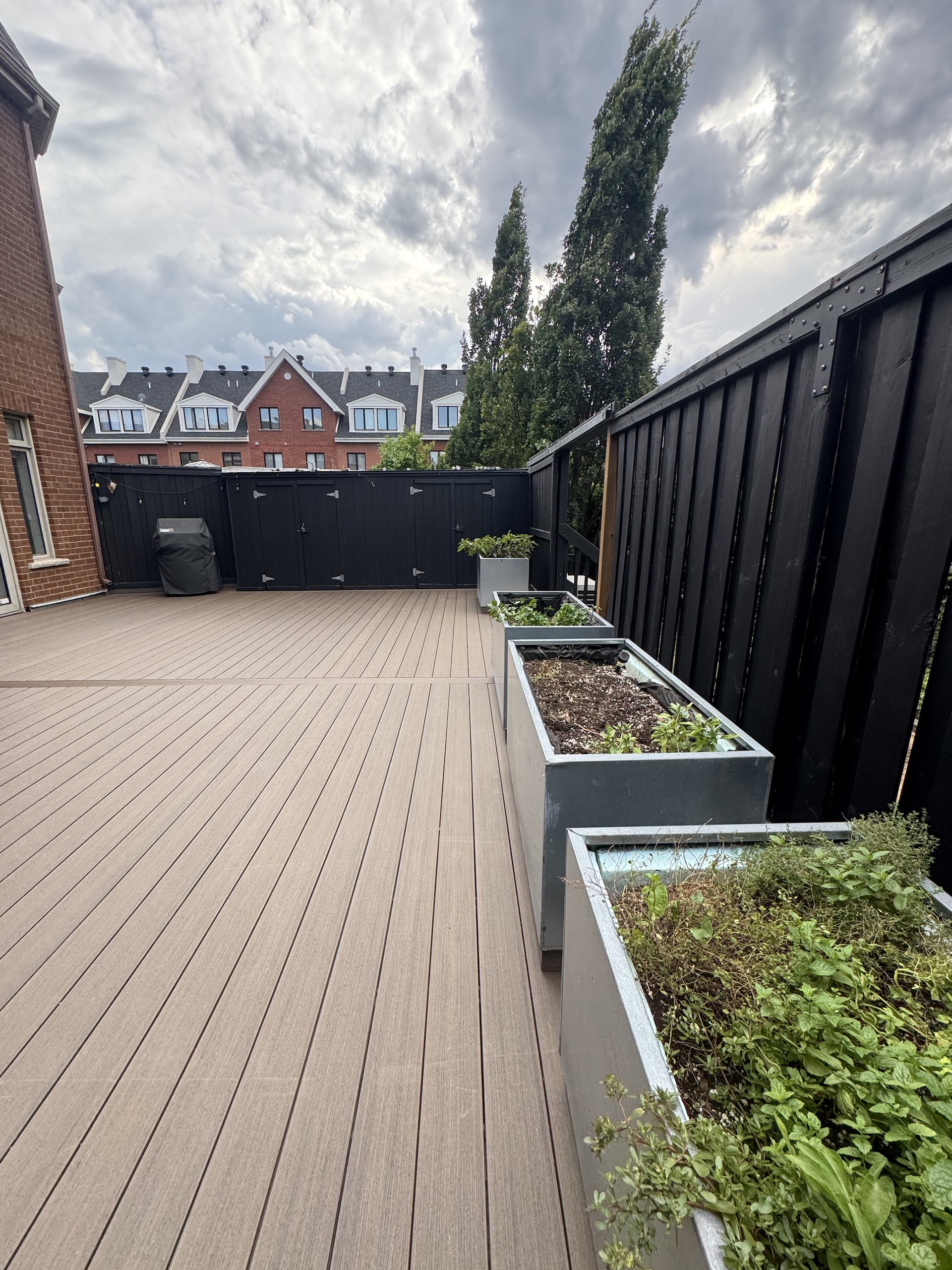 Contemporary outdoor living space with composite flooring and modern metal planters